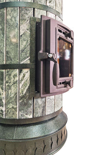 Close up of heavy duty cast iron door latch on green serpentine stone masonry heater