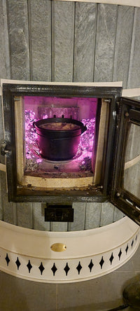 Using a soapstone Siberia masonry heater as an off-grid oven to cook a large pot of stew during the winter.